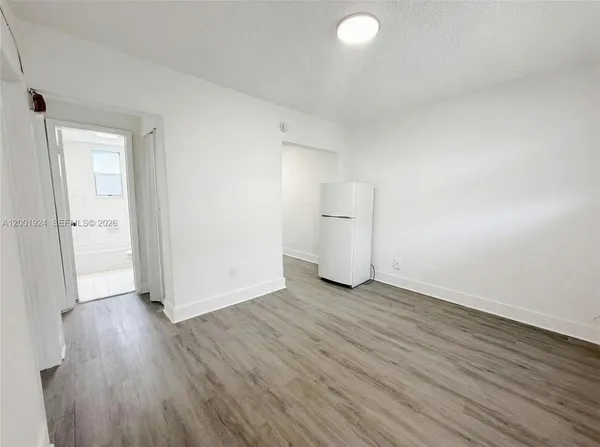 an empty room with wooden floor and white doors