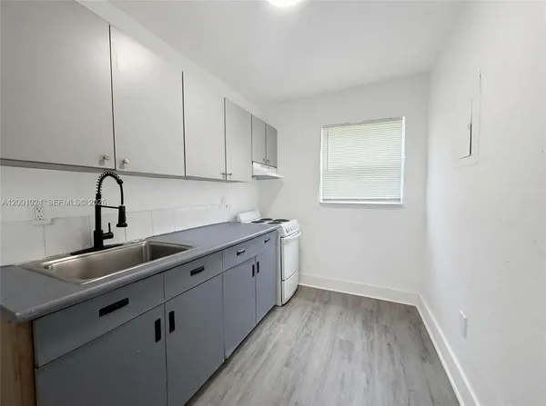 a view of a kitchen with sink and cabinets
