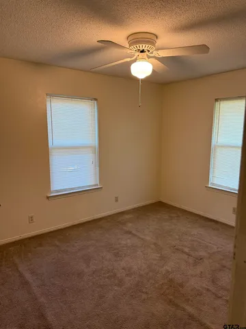 an empty room with a chandelier fan