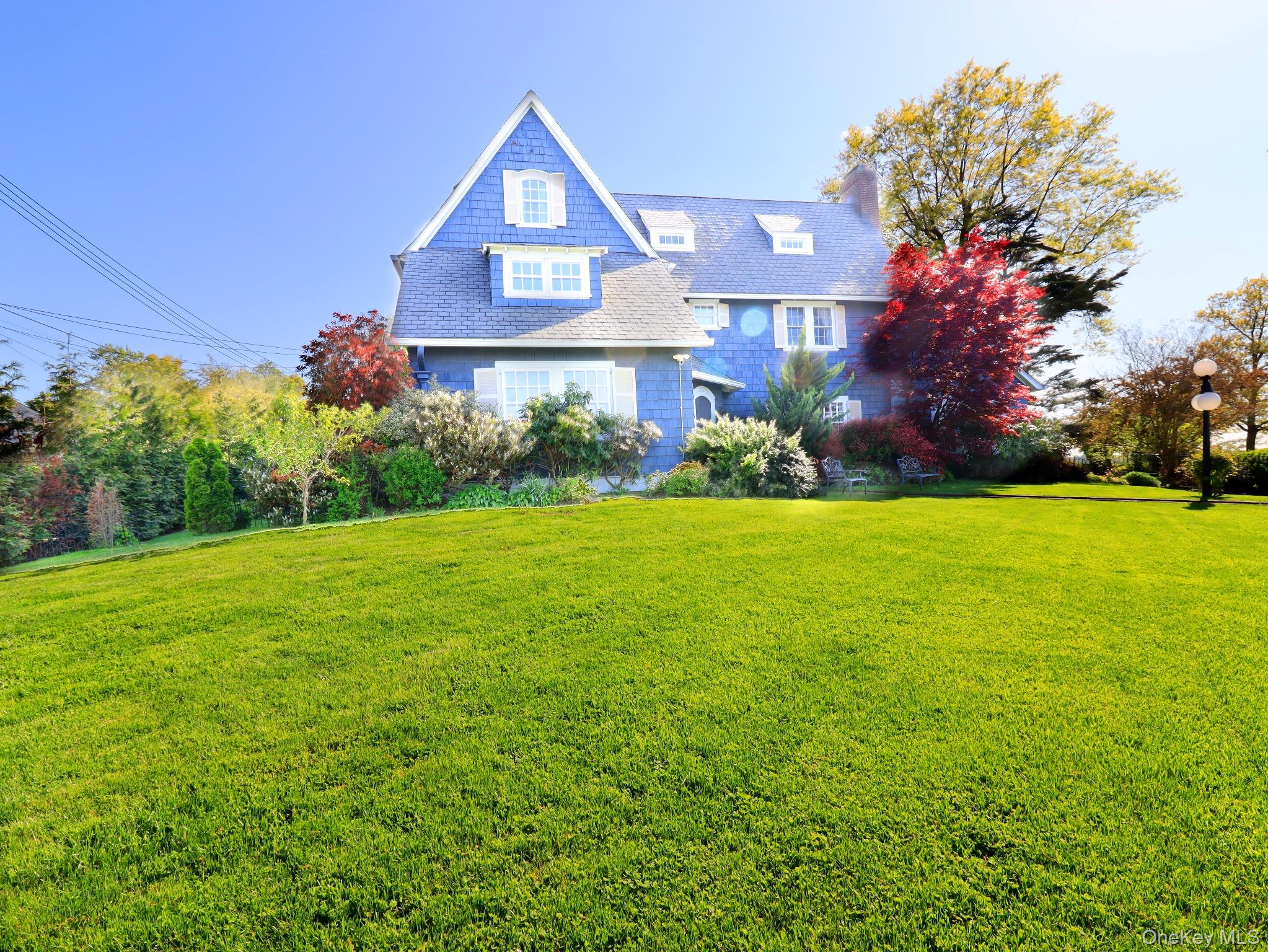 11-20 Shore Road Queens, NY 11363 - Photo 20 of 45 Expansive front lawn with a sloped landscape and mature trees