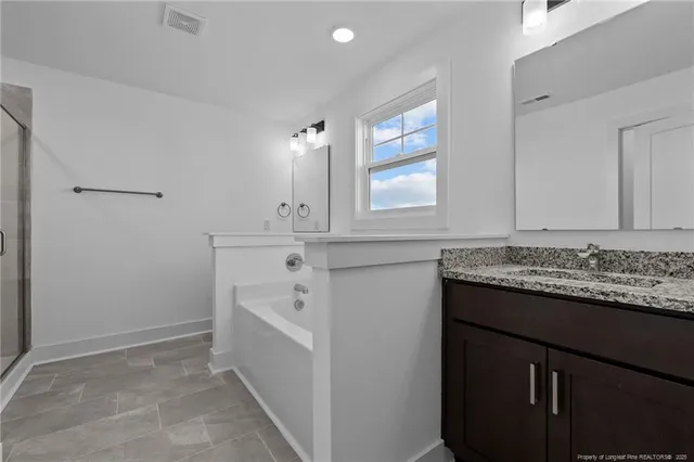 a bathroom with a bathtub a window and vanity