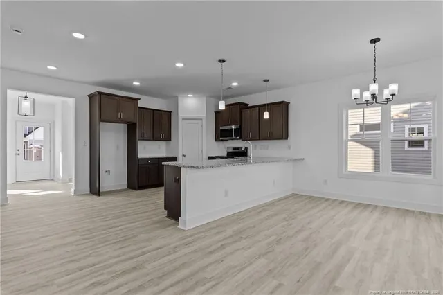 a kitchen with stainless steel appliances granite countertop a sink a stove and a microwave oven