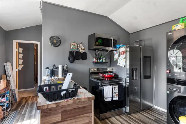 a living room with furniture a flat screen tv and a refrigerator