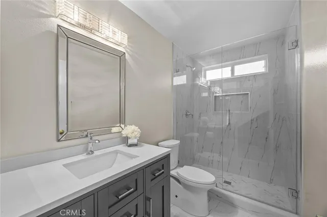 a bathroom with a sink a toilet and shower