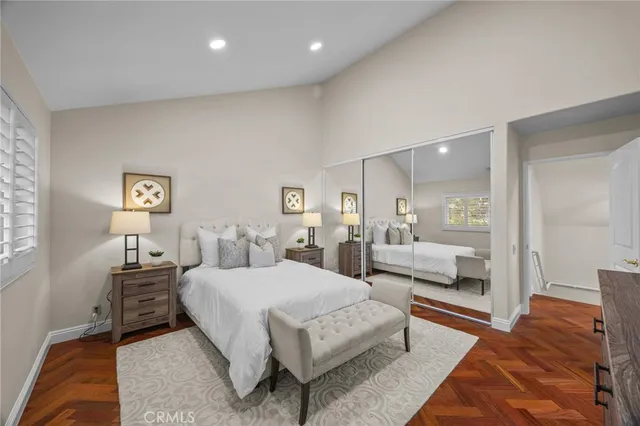 a bedroom with a bed a mirror and lamp