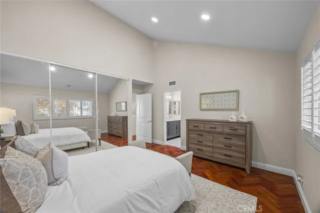 a spacious bedroom with a bed and wooden floor