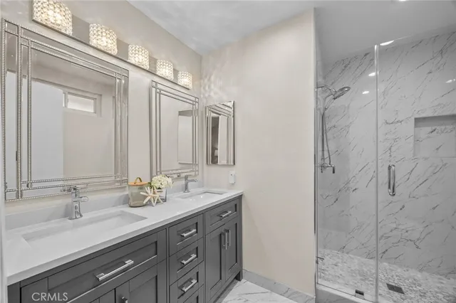 a bathroom with a double vanity sink mirror and shower