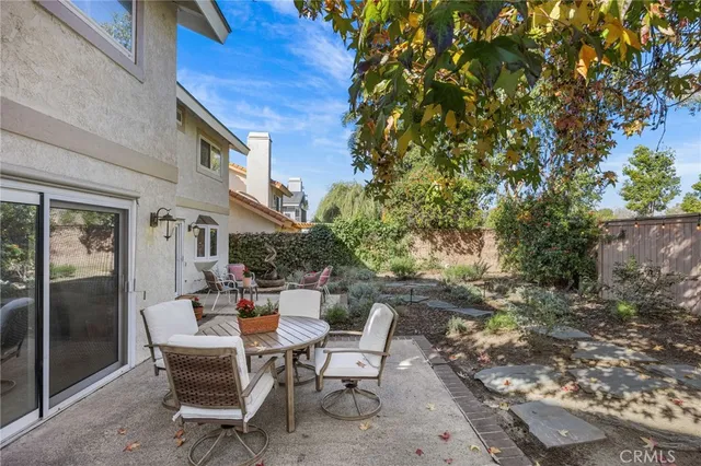 a view of backyard of a house with table and chairs