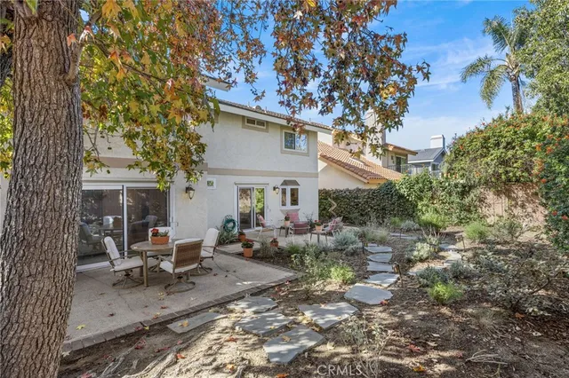 a view of a house with backyard sitting area and garden
