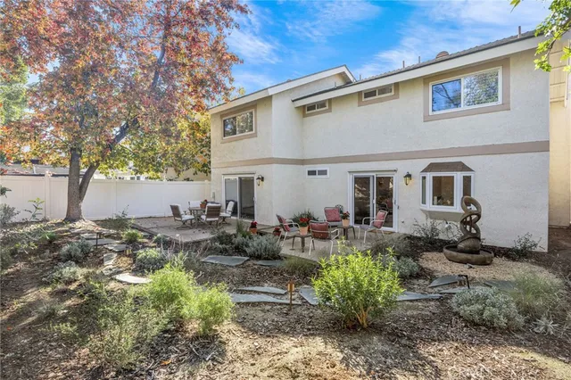 a view of a house with backyard and sitting area