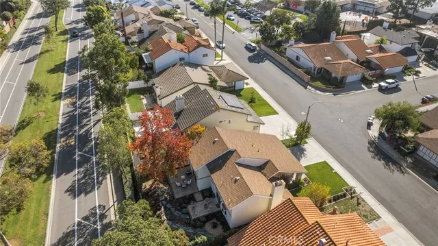 an aerial view of a house with a yard and parking