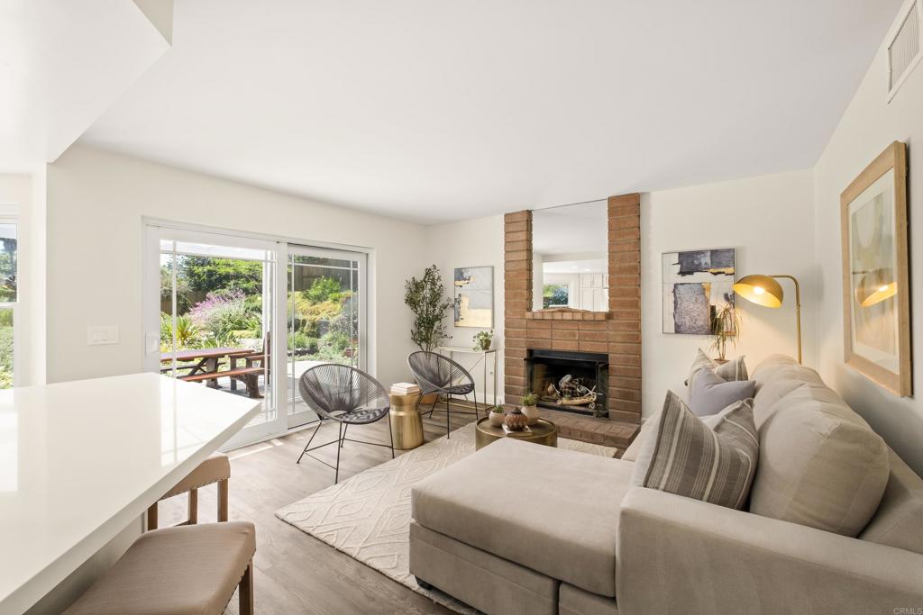 1361 Hodges Road Oceanside, CA 92056 - Photo 17 of 39 a living room with furniture a fireplace and floor to ceiling windows