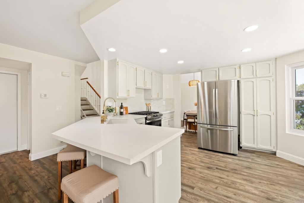 1361 Hodges Road Oceanside, CA 92056 - Photo 10 of 39 a kitchen with stainless steel appliances a refrigerator and wooden floor