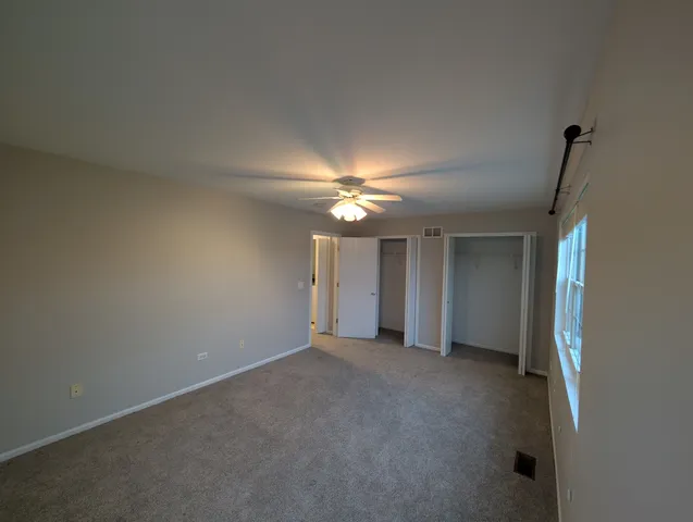 a view of an empty room with a ceiling fan