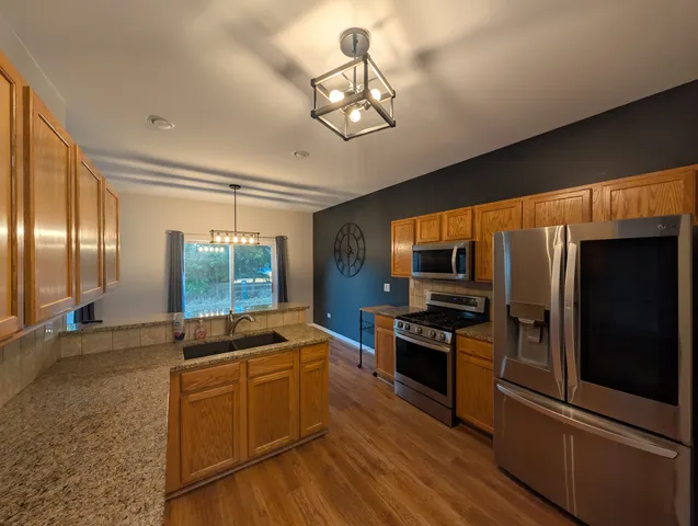a kitchen with stainless steel appliances granite countertop a stove and a refrigerator