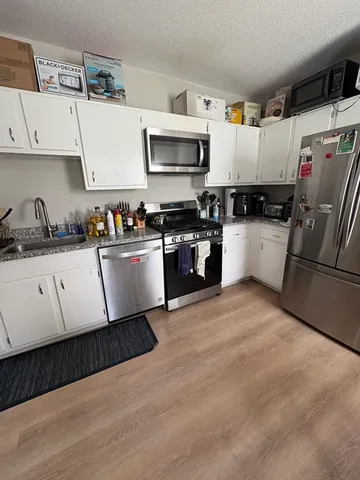 a kitchen with a sink a microwave and cabinets