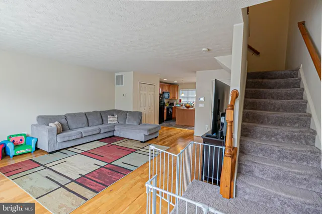 a living room with furniture a rug and white walls