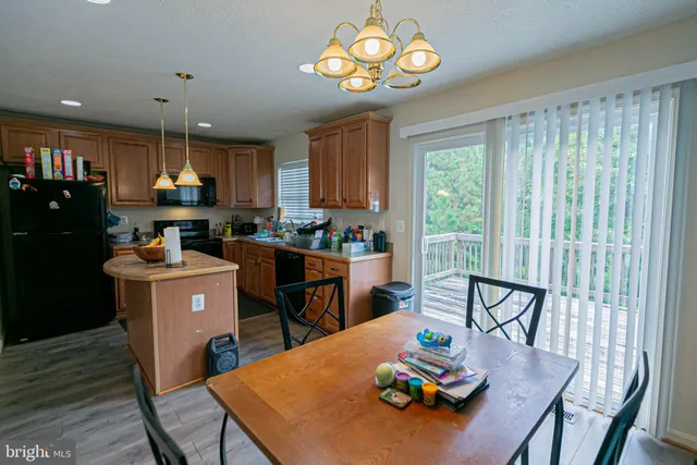 a kitchen with stainless steel appliances a stove a refrigerator a sink dishwasher and a stove with wooden floor