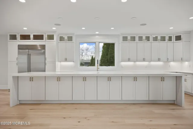 a large white kitchen with a large window