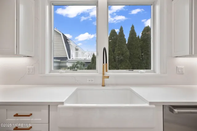 a view of a kitchen with white cabinets and wooden floor