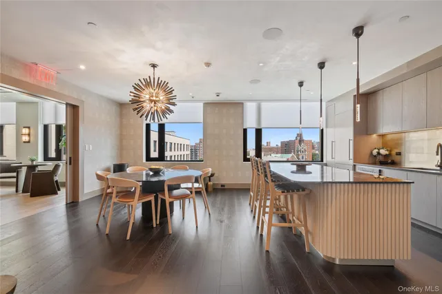 a kitchen with stainless steel appliances granite countertop a table chairs sink and cabinets
