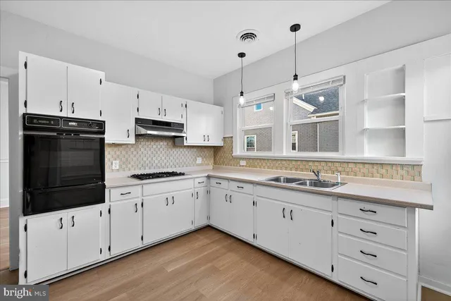 a kitchen with granite countertop white cabinets and white appliances