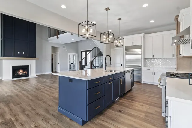 a large kitchen with stainless steel appliances granite countertop a sink a stove and a wooden floors