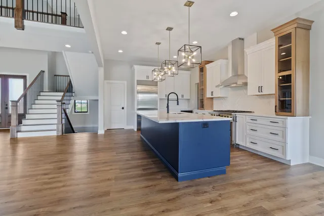 a large kitchen with stainless steel appliances kitchen island granite countertop a large counter top a stove a sink and a cabinets