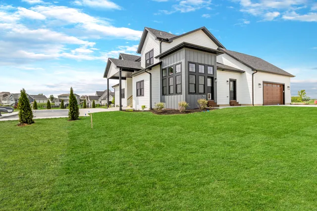 a view of a house with a big yard and large trees