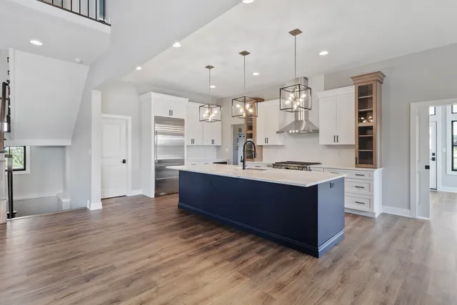 a large kitchen with stainless steel appliances kitchen island granite countertop a large counter top and wooden floors