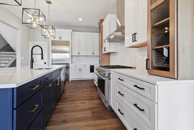a kitchen with cabinets wooden floor and stainless steel appliances