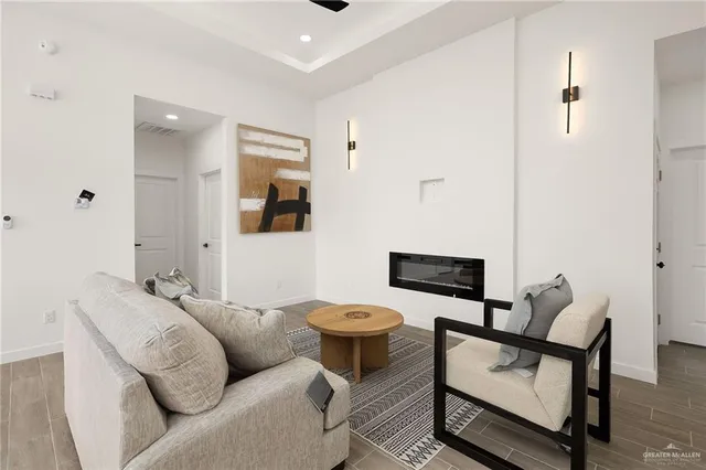 a living room with furniture a flat screen tv and kitchen view
