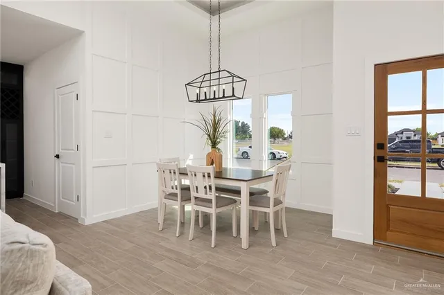 a dining room with furniture a chandelier and wooden floor