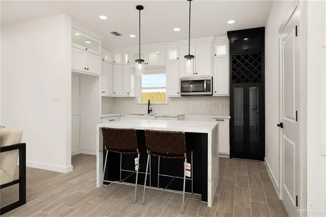 a kitchen with kitchen island a sink stainless steel appliances and cabinets