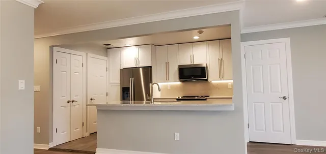 a kitchen with stainless steel appliances a refrigerator and microwave