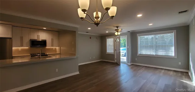 a view of a kitchen with wooden floor and a ceiling fan