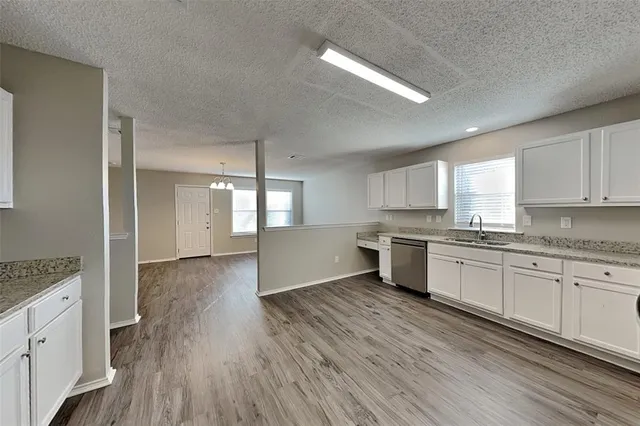 a large kitchen with a wooden floor and stainless steel appliances