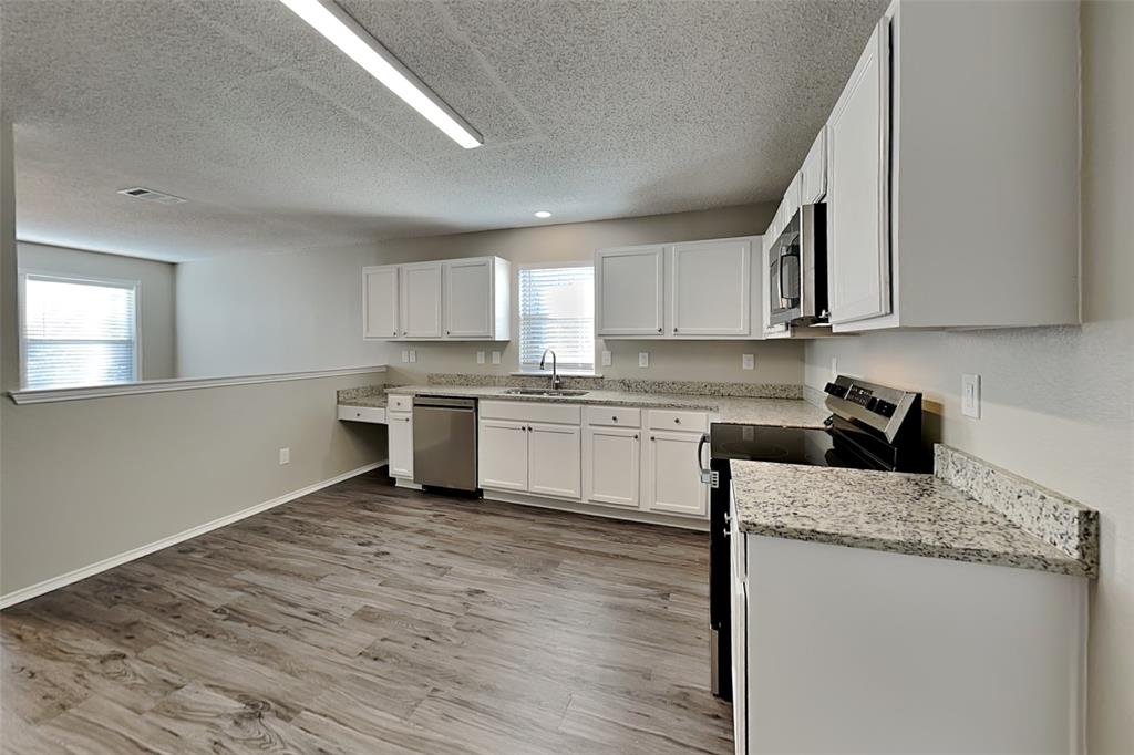 1200 Rambling Brook Trail Denton, TX 76210 - Photo 8 of 21 a kitchen with granite countertop a sink stove and cabinets
