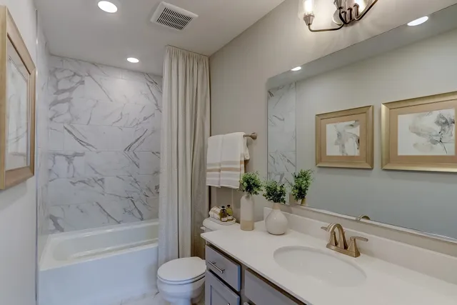 a bathroom with a granite countertop sink a toilet and shower