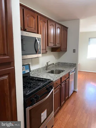 a kitchen with granite countertop stainless steel appliances and wooden cabinets