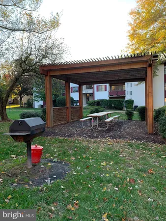 a view of a chair and table in backyard of the house