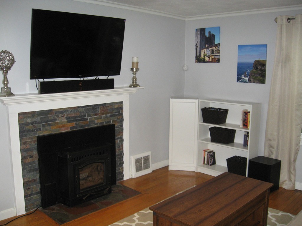 59 Mayflower Road Springfield, MA 01118 - Photo 4 of 27 a living room with a flat screen tv and a fireplace