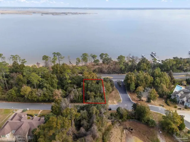 an aerial view of a house with a yard and lake view