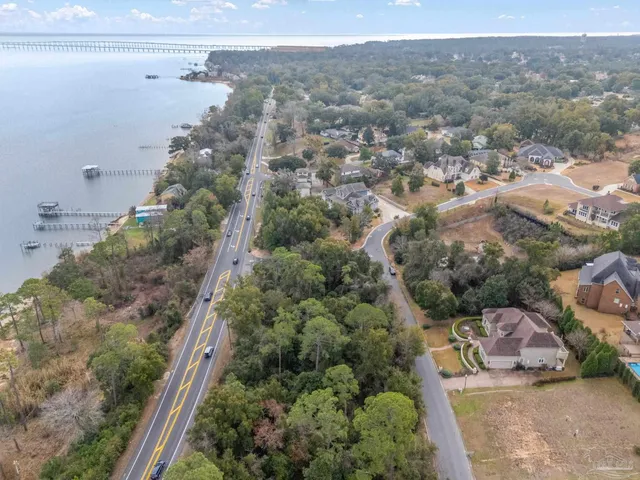 an aerial view of residential houses with outdoor space and trees