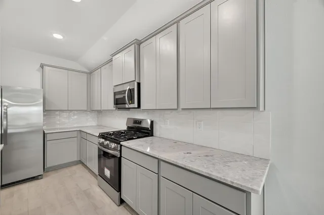 a kitchen with stainless steel appliances granite countertop a sink stove and microwave