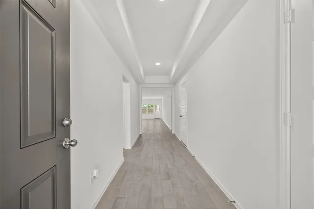 a view of a hallway with wooden floor and entryway