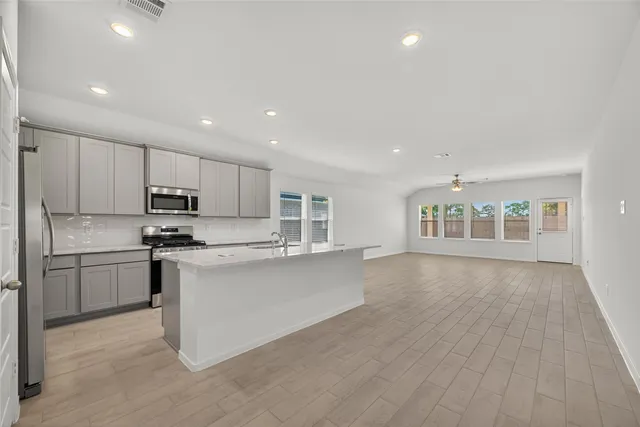 a kitchen with stainless steel appliances granite countertop a refrigerator sink and stove