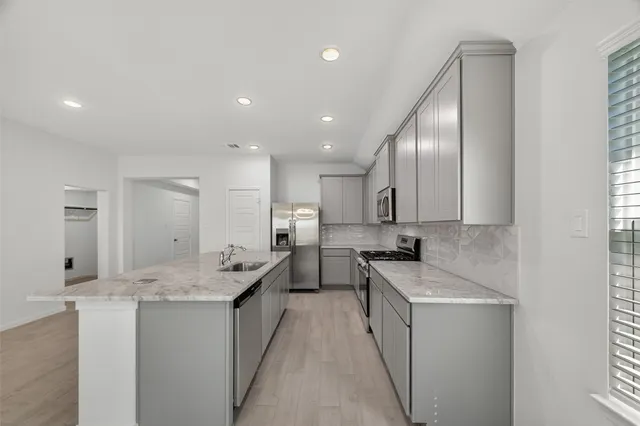 a kitchen with a sink stove and cabinets
