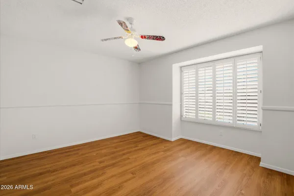 a view of a big room with wooden floor and windows