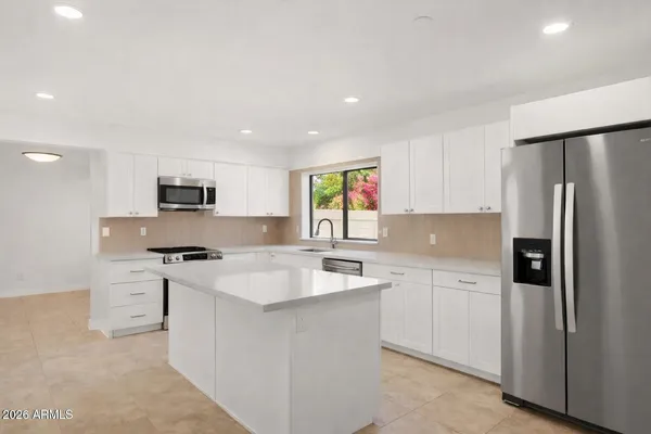 a kitchen with stainless steel appliances granite countertop a sink stove and refrigerator